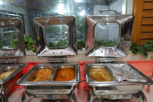 a bunch of trays of food on a counter at SkyCity Hotel Gurgaon in Gurgaon