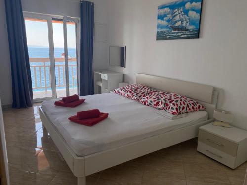a bedroom with a bed with red pillows on it at Villa nad Morem in Podaca