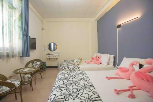 two pink flamingos sitting on beds in a room at QG Simple Life in Jincheng