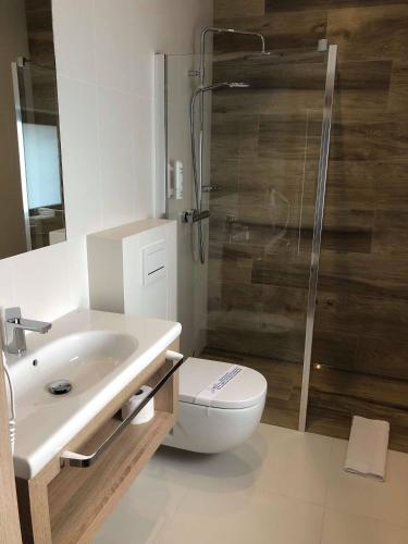 a bathroom with a toilet and a sink and a shower at Willa Wiosna in Września