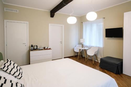 a bedroom with a large white bed and a table at Flora Inn, Scotti's House - Due passi in centro in Bergamo