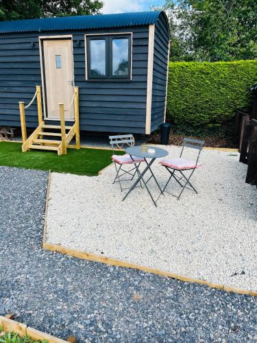a patio with two chairs and a table in front of a tiny house at The Burds Nest in West Hatch