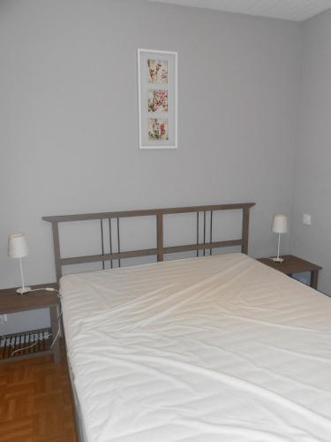 Ce lit se trouve dans un dortoir doté de 2 tables et de 2 lampes. dans l'établissement Superbe villa 4 ch climatisées avec piscine privée, à Roquetaillade