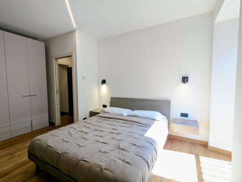 a bedroom with a large bed in a white room at Domus Aurea in Domodossola