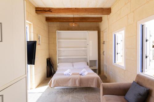 a bedroom with a bed with two towels on it at Historic Hideaways - 900 Year Old Converted Studios in Victoria