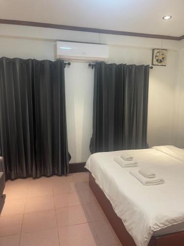 a bedroom with black curtains and a bed at ksana guesthouse in Luang Prabang