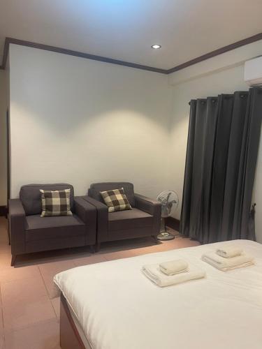 a living room with two beds and a couch at ksana guesthouse in Luang Prabang