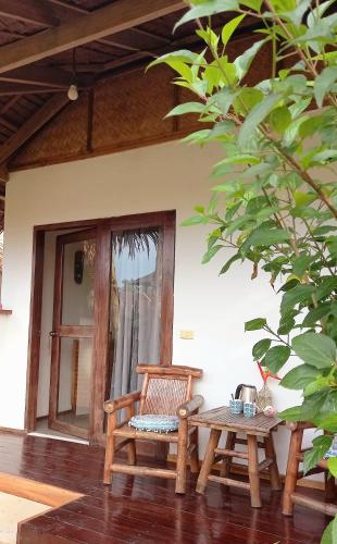 a wooden bench and a table in front of a house at Valerie Lodge in San Vicente
