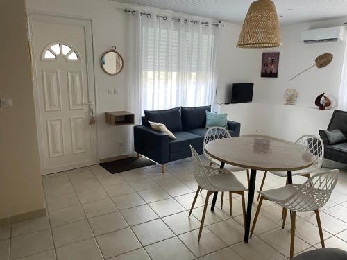 a living room with a table and a couch at Cosy T3 au coeur de Sainte Anne in Sainte-Anne
