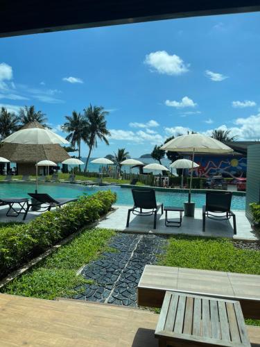 a pool with tables and chairs and umbrellas at Kai Bae Beach Resort Koh Chang in Ko Chang