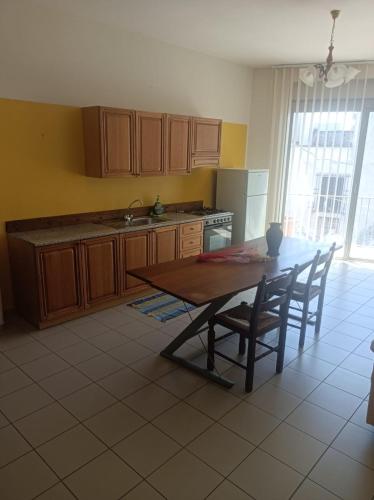 a kitchen with a wooden table and a table and chairs at SteLuRe in Aradeo