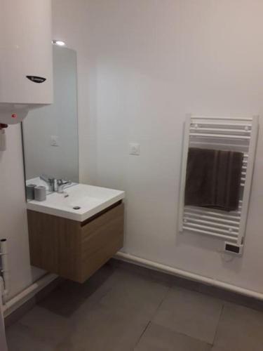 une salle de bain blanche avec un lavabo et un miroir dans l'établissement Louthalia Congrès centre ville, à Reims