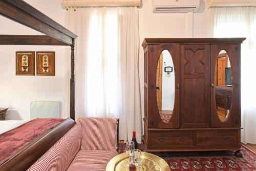 a bedroom with a bed and a dresser with a mirror at Centre-Ville Guest House in Franschhoek