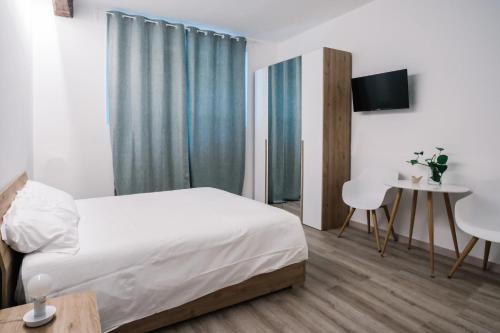 a bedroom with a bed and a table and a desk at Flora Inn, Scotti's House - Due passi in centro in Bergamo