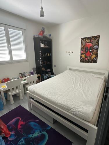 une chambre avec un lit blanc et une table dans l'établissement Maison de standing climatisée, à Lattes