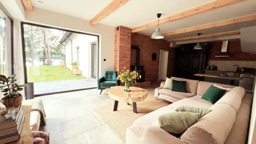a living room with a couch and a table at Stara Szafa - Komfortowy dom nad jeziorem in Łajs