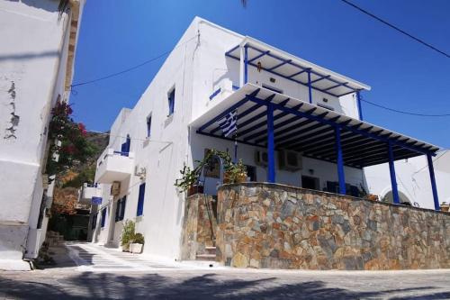 キティラにあるTakis Seaside Apartmentの石の壁に青いアクセントが付いた白い建物