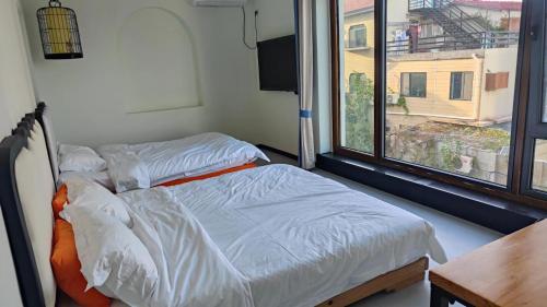 a hospital room with two beds and a window at 威海蜂舍民宿 in Weihai