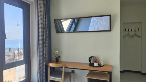 a mirror on a wall next to a table and a window at 威海蜂舍民宿 in Weihai