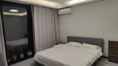 a bedroom with a bed and a large mirror at 威海蜂舍民宿 in Weihai