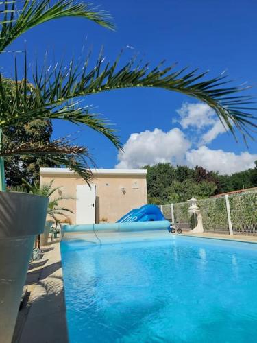 une grande piscine bleue avec un gonflable bleu dans l'établissement Au Coeur des Vignes Médoc, à Saint-Sauveur