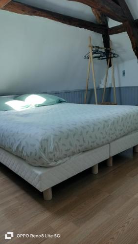 Cette chambre comprend un grand lit et du parquet. dans l'établissement Maison de village cosy, à Saint-Eustache-la-Forêt