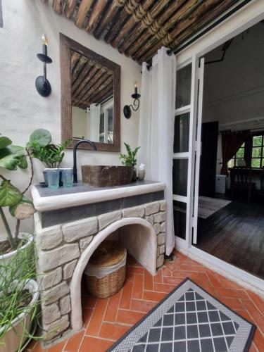a patio with a stone fireplace and a mirror at Naturetalk Homestay in Ban Don
