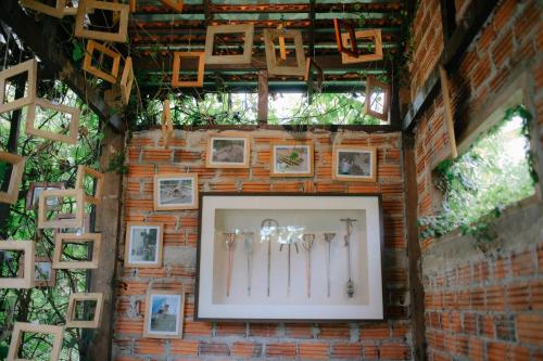 a brick wall with framed pictures on it at Naturetalk Homestay in Ban Don