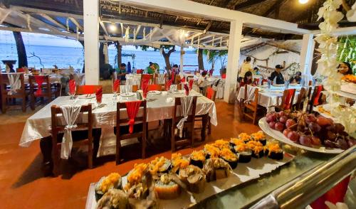 een restaurant met tafels met eten erop bij Evangeline Resort in Pagudpud