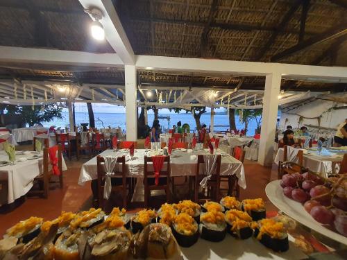 een eetkamer met tafels met eten erop bij Evangeline Resort in Pagudpud