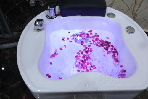 a white toilet with pink sprinkles on it at SkyCity Hotel Gurgaon in Gurgaon