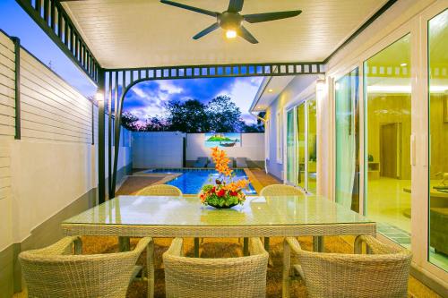 a dining room with a table and chairs and a ceiling fan at "Smooth as Silk" Gorgeous 3-Bedroom Pool Villa, Just a Stone's Throw from the Beach! in Ban Khlong Haeng