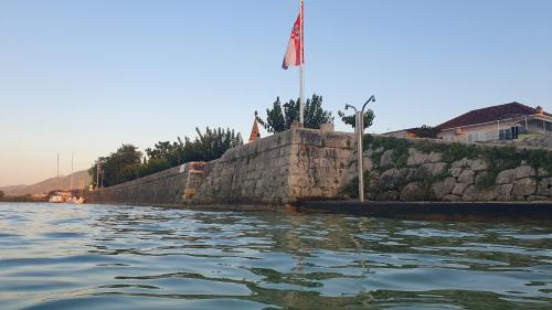 a stone wall with a flag on top of it at Holiday house - Dvori Vlahovici in Opuzen