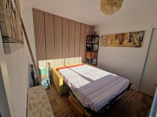 une petite chambre avec un lit dans une pièce dans l'établissement Les Zèbres- Wifi-Jacuzzi-Vélos-Ecran plat- Chambres parentales- Baignoire, à La Rochelle