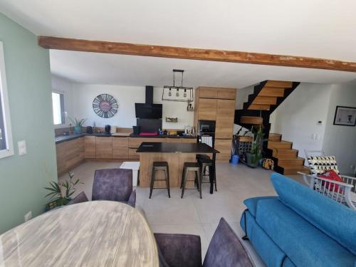 un salon avec un canapé bleu et une table dans l'établissement Les Zèbres- Wifi-Jacuzzi-Vélos-Ecran plat- Chambres parentales- Baignoire, à La Rochelle