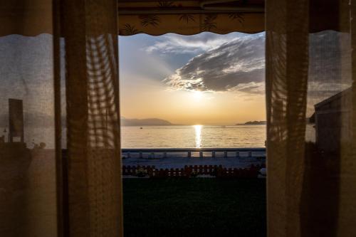 a view from a window of the ocean at sunset at Loutraki Sea Sunset in Loutraki