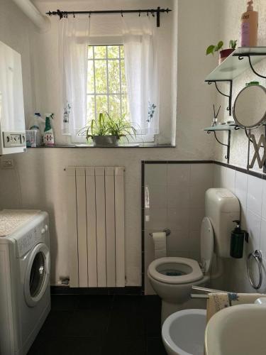 a bathroom with a toilet and a sink and a window at Crosa Rosella in Bardineto