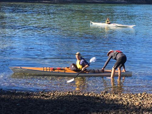 two people are in a kayak on the water at Fully fenced, wrap around decks, water on 3 sides in Lunawanna