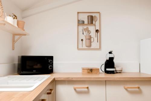 une cuisine avec un comptoir avec un micro-ondes dans l'établissement Charmante Maisonnette, à Montreuil-Bellay
