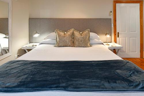 a bedroom with a large bed with two lamps at Centre-Ville Guest House in Franschhoek