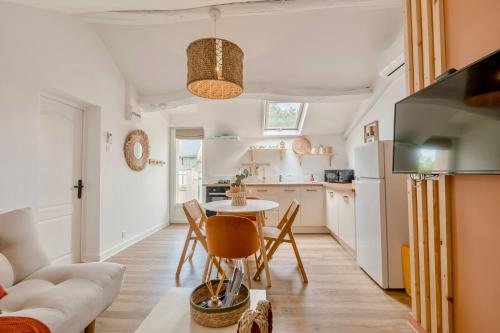 une cuisine et un salon avec une table et des chaises dans l'établissement Charmante Maisonnette, à Montreuil-Bellay