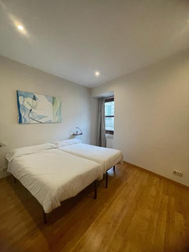 ein weißes Schlafzimmer mit zwei Betten und einem Fenster in der Unterkunft Casco Vello Vigo Oliva 8 in Vigo