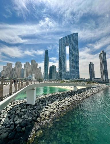 a bridge over a body of water in front of a city at Palmar One Bedroom with Private Beach! in Dubai