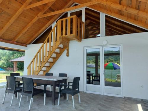 a patio with a table and chairs and a wooden staircase at Vikendica Maksim, Zelinje - Zvornicko jezero in Zvornik