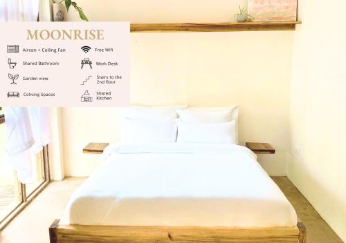 a bed in a room with a sign on the wall at Secret Spot Siargao in General Luna