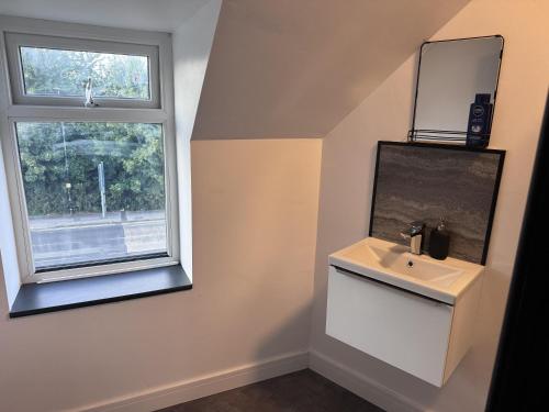 a bathroom with a sink and a window at City Apartment Sleeps 5 with Parking in Manchester