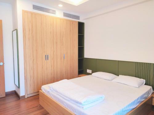 a bedroom with a bed and a wooden door at FLC Sea Tower Quy Nhơn, ban công view biển, bồn tắm, hồ bơi có phí , gần quản trường in Quy Nhon