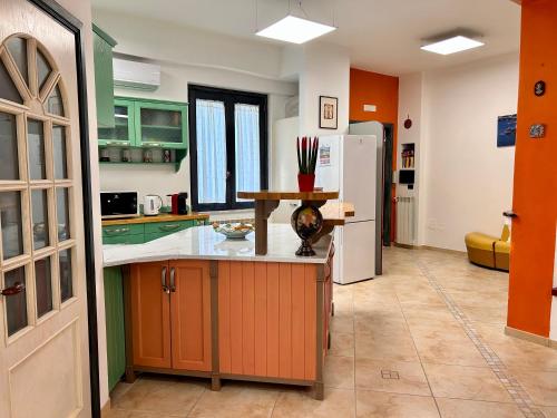 a kitchen with orange and green cabinets and a white refrigerator at Seamply apartment il mare in 1 minuto in Maiori
