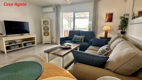 a living room with a couch and a tv at Casas Pedro & Agata in Morro del Jable