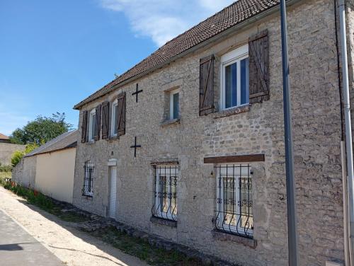 un vieux bâtiment en briques avec des fenêtres à barreaux sur une rue dans l'établissement La Forge, à Santilly